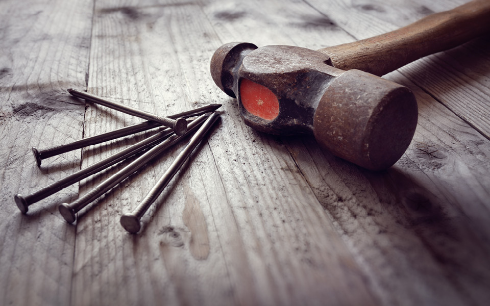 Hammer and nails on wooden surface